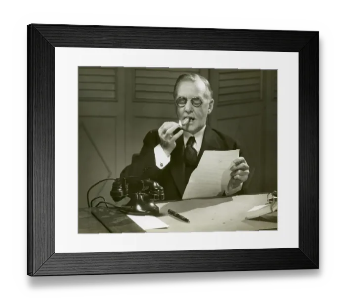 Framed Print : Mature man lights cigar at desk Framed Print : Mature man lights cigar at desk