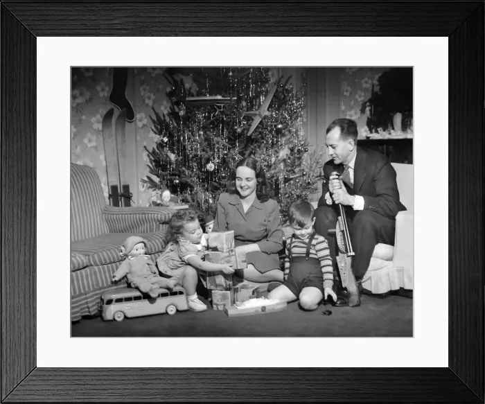 Framed Print : Family sitting in front of Christmas tree Framed Print : Family sitting in front of Christmas tree