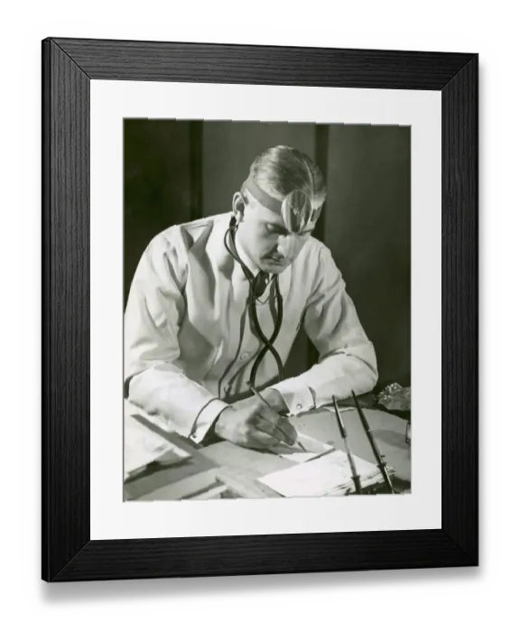 Framed Print : Doctor writes at his desk Framed Print : Doctor writes at his desk