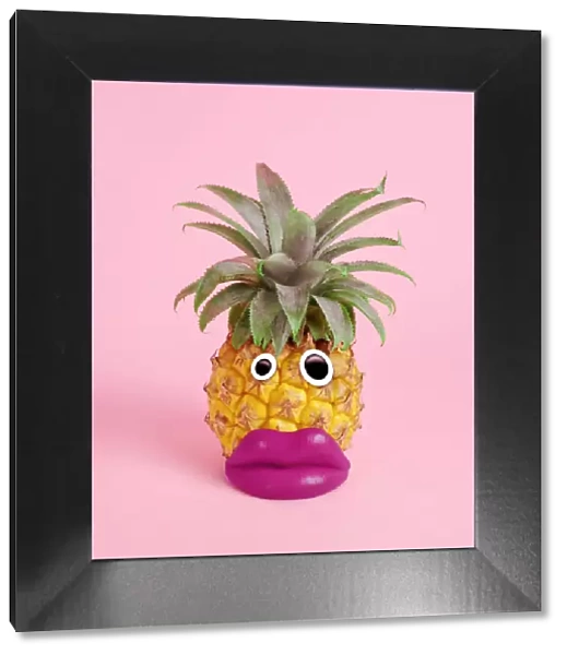 pineapple with face made of fake lips and googly eyes