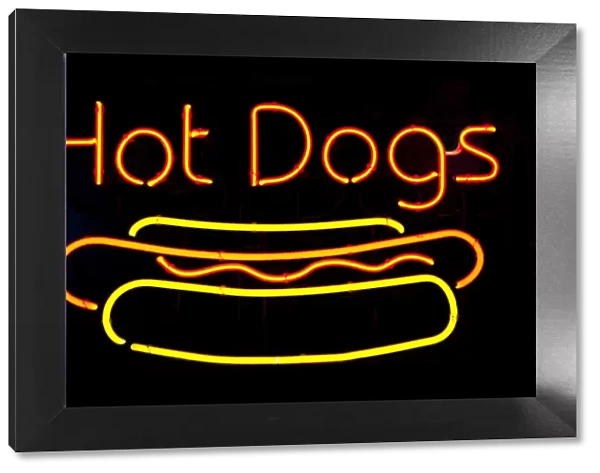 Neon hot dog sign on black background