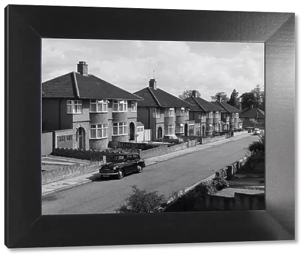 Suburbia. circa 1965: A suburban street with rows of semi-detached houses