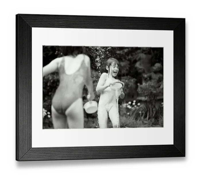 Framed Print : Two girls (7-9) in swimwear having water fight in garden (B&W) Framed Print : Two girls (7-9) in swimwear having water fight in garden (B&W)
