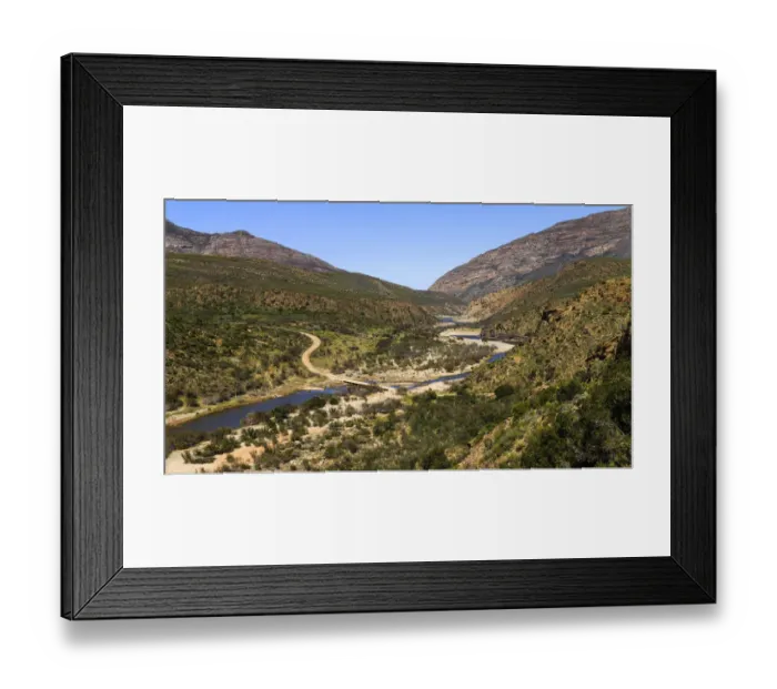 Framed Print : A gravel road in a mountainous area crossing over a river on a low level bridge near Framed Print : A gravel road in a mountainous area crossing over a river on a low level bridge near