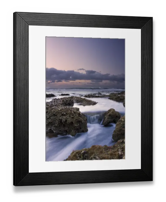 Framed Print : Beautiful soft colour sunrise over the sea with rocks in the foreground - Cape Vidal South Africa