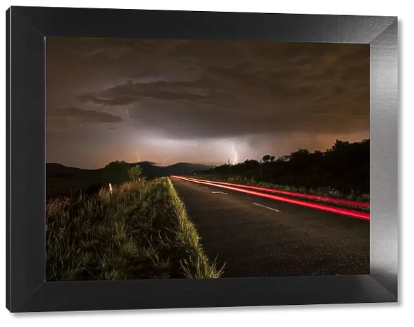 A thunderstorm at night with lightning on a remote road in the Cradle of Humankind, Magaliesburg, Gauteng Province, South Africa