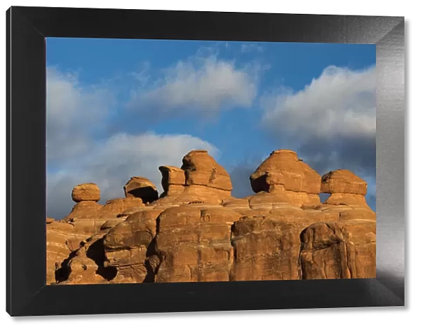 Eroded rock formations at sunset in Arches National Park with clouds, Utah, USA