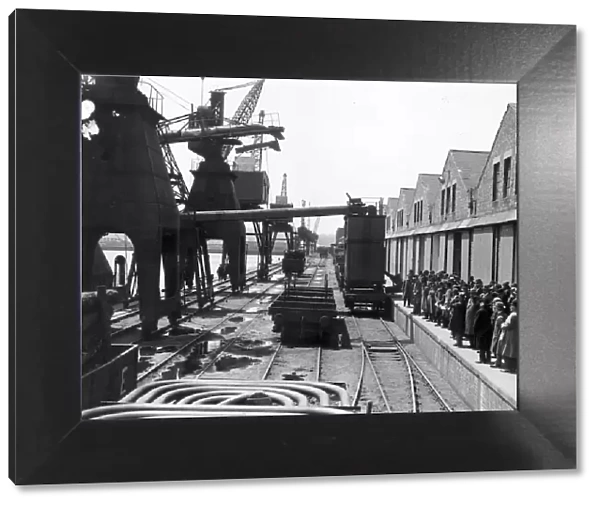 Dock Yard. 24th June 1927: Spectators gaze at a giant grain elevator at