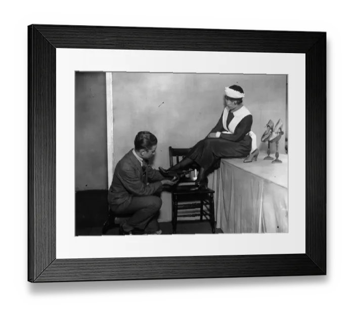 Framed Print : Shoe Fair. 5th September 1925: A waitress trying on a pair of the latest Framed Print : Shoe Fair. 5th September 1925: A waitress trying on a pair of the latest