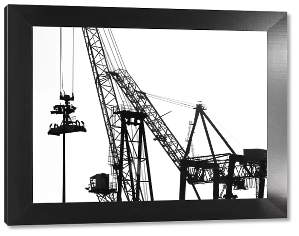 Silhouetted profile of construction cranes