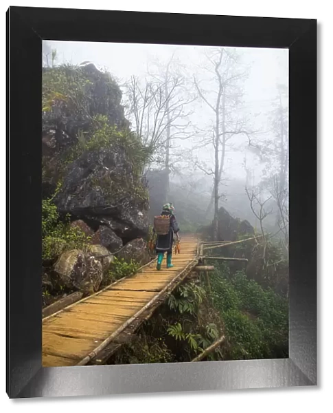 Hmong minority steps on wood staircase in Sa Pa