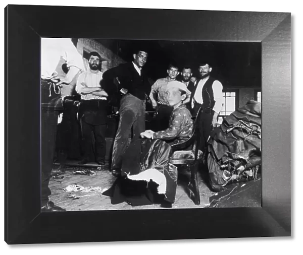 Sweatshop. A Photograph of Young Boy and Several Male Workers in a Sweatshop by Jacob Riis