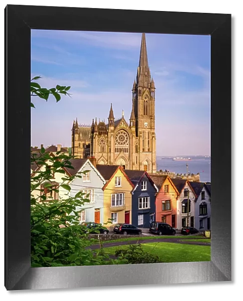 Row of colorful houses with cathedral background in Cobh, County Cork, Ireland
