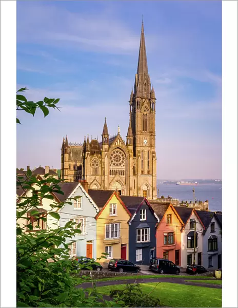 Row of colorful houses with cathedral background in Cobh, County Cork, Ireland