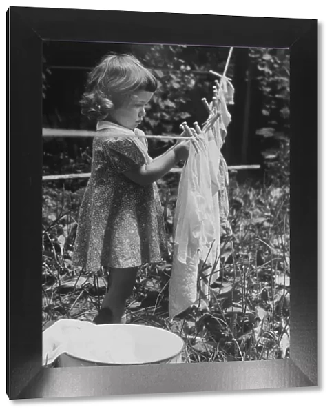 GIRL PINS LAUNDRY TO CLOTHESLINE, 1944