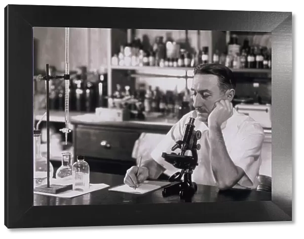 Scientist doing research in lab, 1930s (B&W)