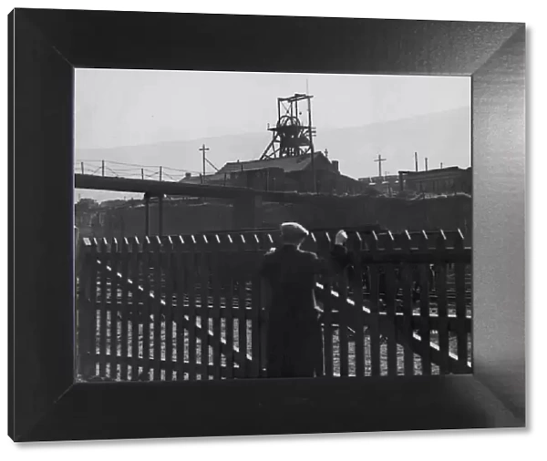Idle Pit. A man looks over a fence to the deserted Gorki pit near Mountain Ash