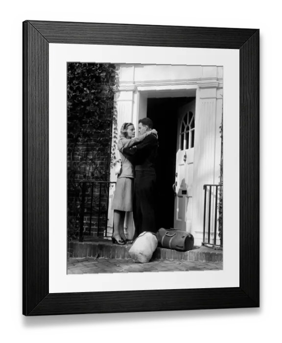 Framed Print : Sailor with duffel bags, hugging woman, about to kiss on front doorstep