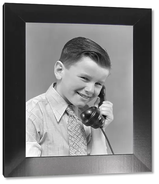 Boy talking on telephone, smiling