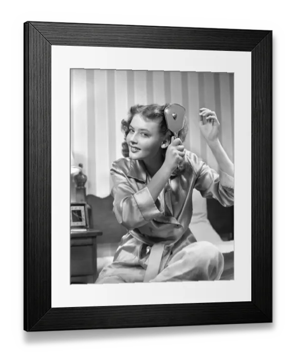 Framed Print : Smiling teenage girl in bathrobe brushing hair in the morning Framed Print : Smiling teenage girl in bathrobe brushing hair in the morning