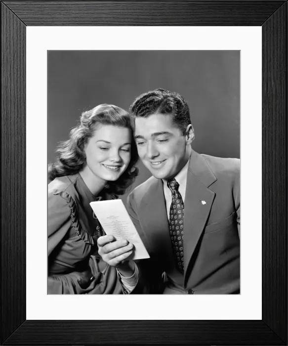 Framed Print : Smiling couple looking at insurance policy brochure Framed Print : Smiling couple looking at insurance policy brochure