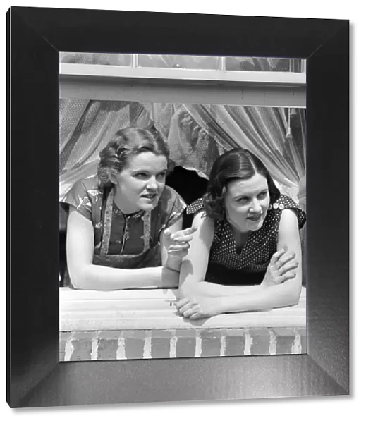 Two women look out an open window