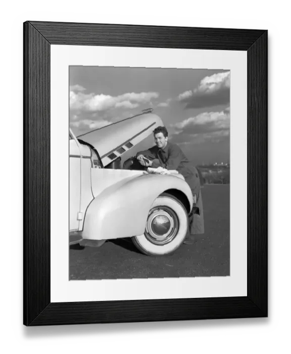 Framed Print : Smiling man in coveralls under hood of sedan, holding monkey wrench Framed Print : Smiling man in coveralls under hood of sedan, holding monkey wrench