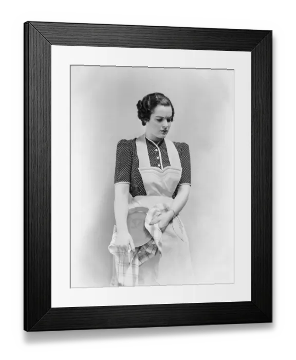 Framed Print : Worried woman in apron, drying dish Framed Print : Worried woman in apron, drying dish