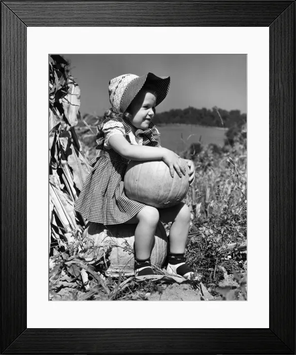 Framed Print : Girl sitting on pumpkin, wearing sun bonnet
