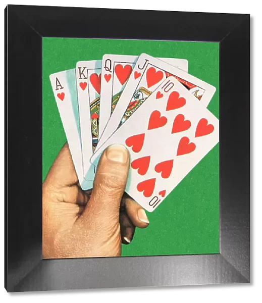 A hand holding a royal flush cards