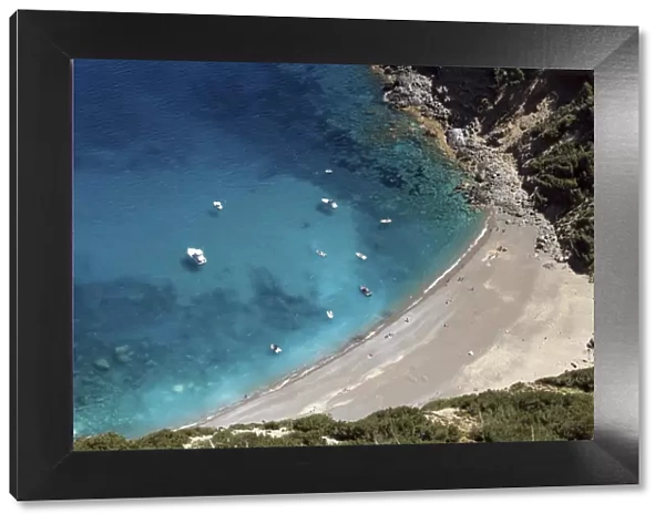 View on the beach Platja des Coll Baix, turquoise blue water, anchoring boats, peninsula