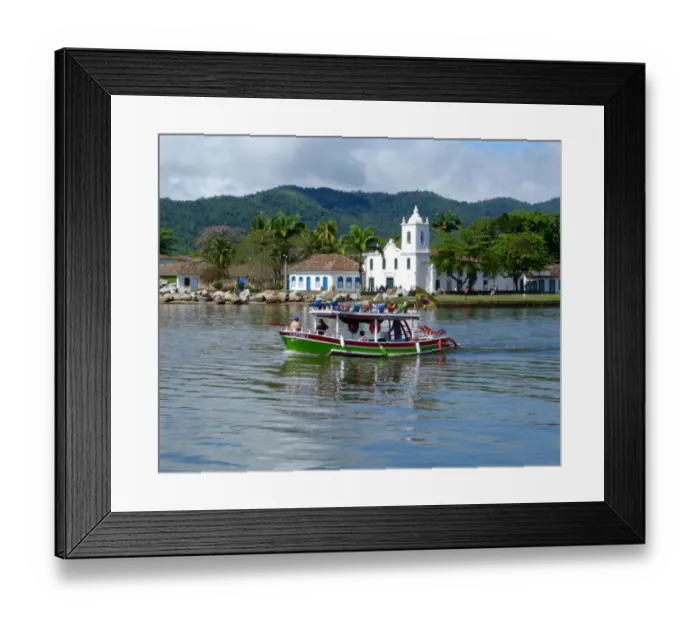 Framed Print : Colourful boat sailing with the pretty Brazilian town Paraty in the back ground