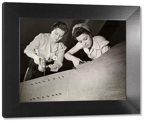 Women working on WW II aircraft assembly