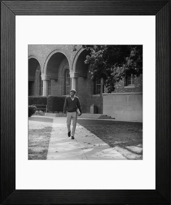 Framed Print : Young man with books walking on campus Framed Print : Young man with books walking on campus