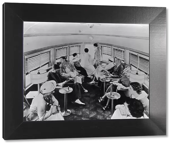 Club Car. A group of passengers lounge in a trains cone-shaped club car