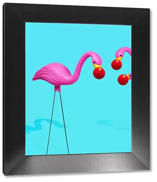Three plastic flamingos wearing red noses