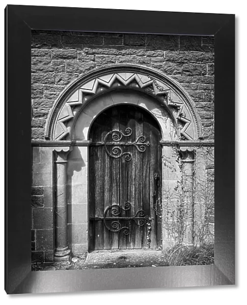 Old church door with stone arch and ornate hinges