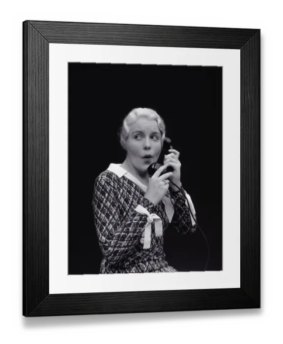 Framed Print : Woman with worried expression, on telephone. (Photo by H Framed Print : Woman with worried expression, on telephone. (Photo by H
