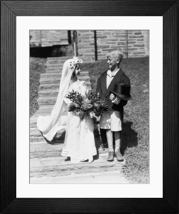 Framed Print : Boy and girl dressed up as bride and groom, outdoors on steps Framed Print : Boy and girl dressed up as bride and groom, outdoors on steps