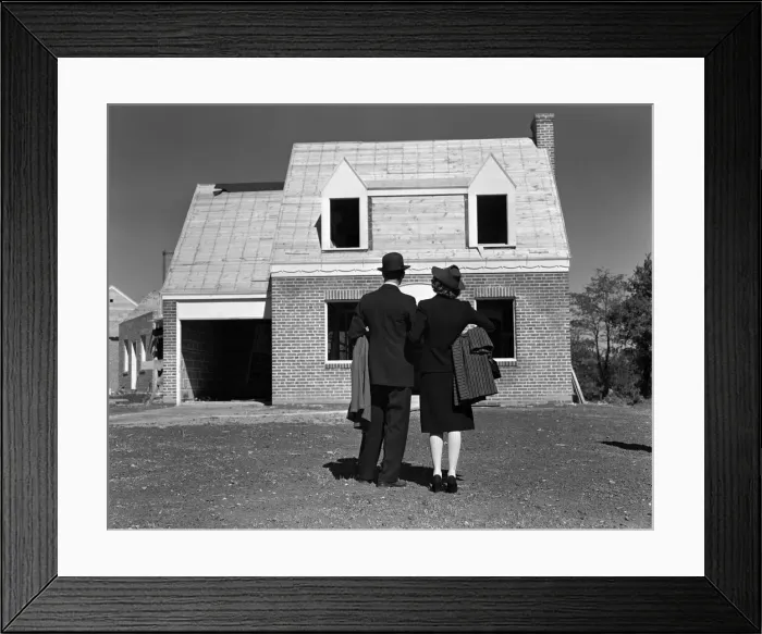 Framed Print : Couple looking at brick house under construction, rear view Framed Print : Couple looking at brick house under construction, rear view