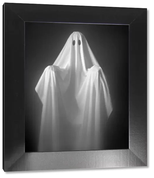 Person Wearing A Ghost Costume, Made Out Of A White Sheet With Two Holes In It