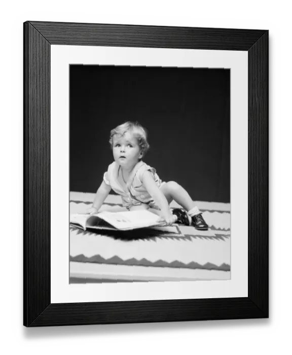 Framed Print : Toddler boy with open book, looking away Framed Print : Toddler boy with open book, looking away