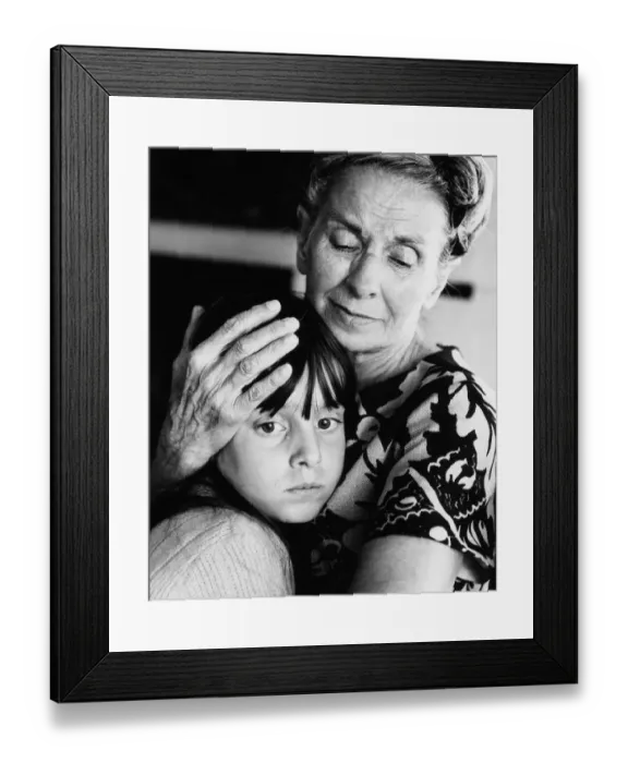 Framed Print : Elderly woman embracing and comforting forlorn-looking granddaughter