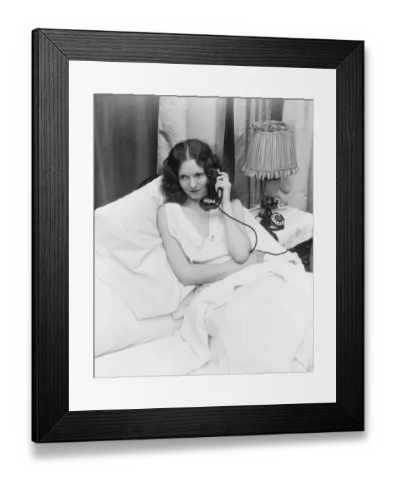 Framed Print : Woman sitting in bed, talking on phone Framed Print : Woman sitting in bed, talking on phone