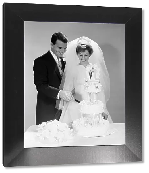Bridge and groom cutting three-tiered wedding cake