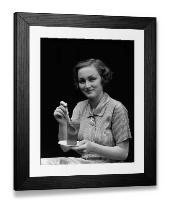 Framed Print : Woman in checked dress, stirring a glass of iced tea, portrait Framed Print : Woman in checked dress, stirring a glass of iced tea, portrait