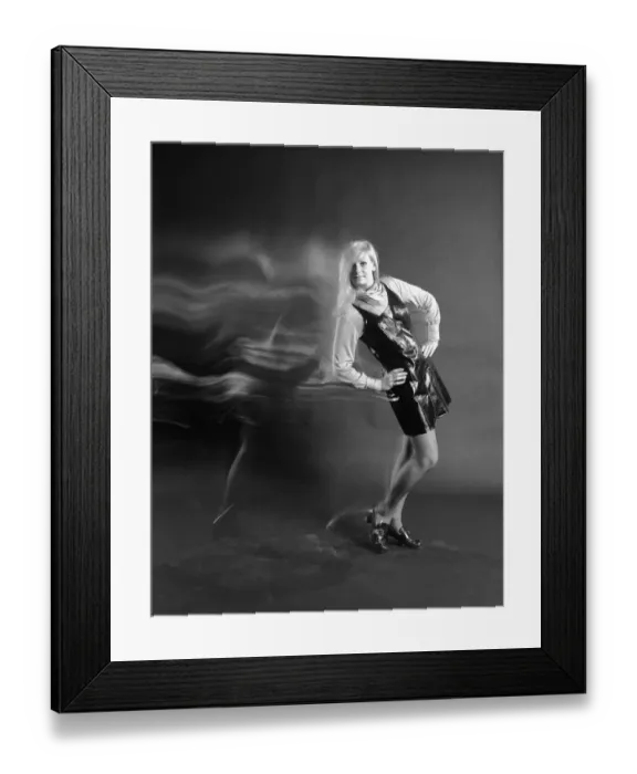 Framed Print : Woman with long blond hair wearing vinyl dress and scarf around neck with hands on hips Framed Print : Woman with long blond hair wearing vinyl dress and scarf around neck with hands on hips