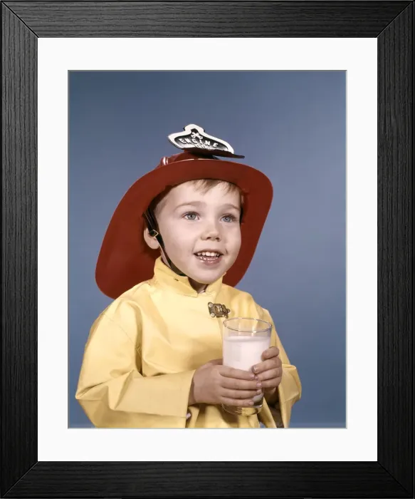 Framed Print : Boy in fireman costume, holding a glass of milk Framed Print : Boy in fireman costume, holding a glass of milk