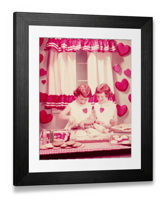 Framed Print : Twin girls in kitchen, baking Valentine cookies