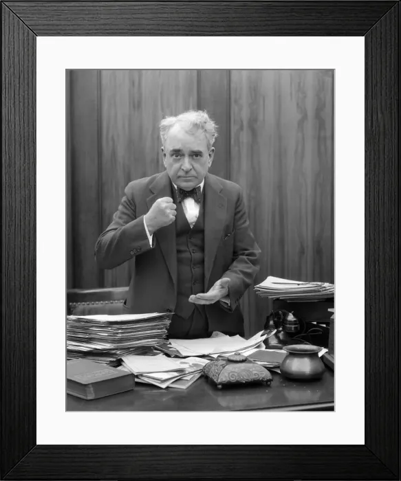 Framed Print : Head-On Picture Of Angry Businessman, Sitting Behind A Desk And Making A Fist Framed Print : Head-On Picture Of Angry Businessman, Sitting Behind A Desk And Making A Fist